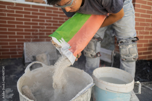 construction assistant pouring cement preparing the mixture