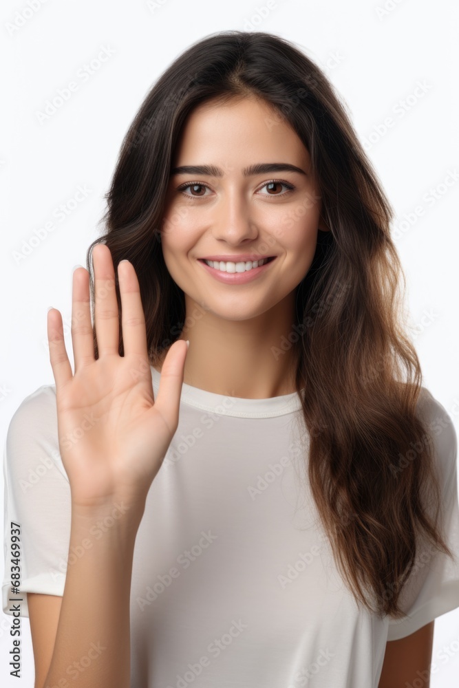 A beautiful young woman confidently makes a stop sign gesture with her hand. A beautiful young woman confidently makes a stop sign gesture with her hand.