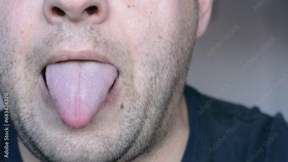 Lower part of the face of a middle-aged man. eats and licks his lips. close up soft focus Lower part of the face of a middle-aged man. eats and licks his lips. close up soft focus