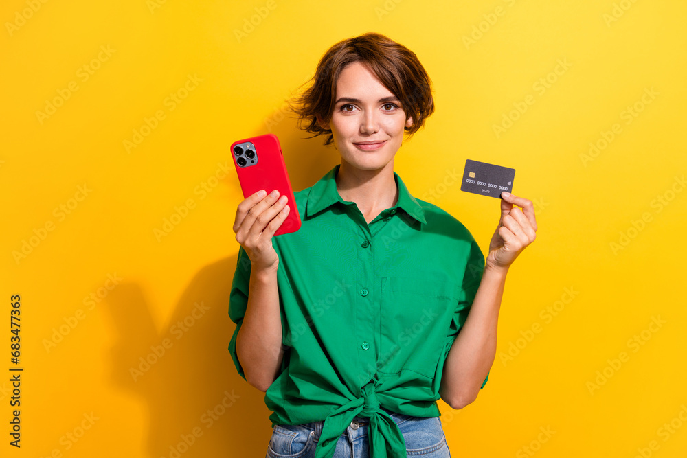 Photo of cheerful positive girl dressed green shirt online shopping modern gadget isolated yellow color background