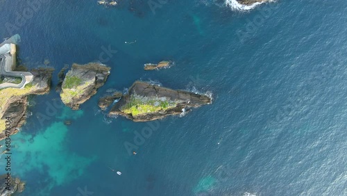 Dunquin or Dun Chaoin pier, Ireland's Sheep Highway. Aerial top-down view of narrow pathway winding down to the pier, ocean coastline. Popular iconic location on Slea Head Drive and Wild Atlantic Way. photo