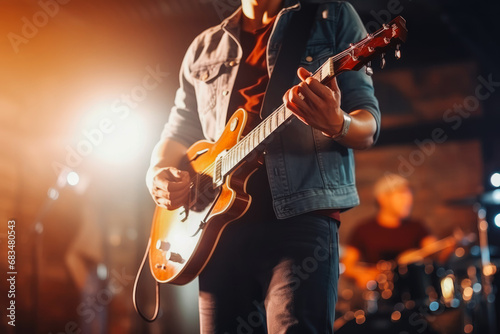 Close up of guitarist from music band playing on stage, band performing for live crowd in a pub, concept of live music and performing on stage photo