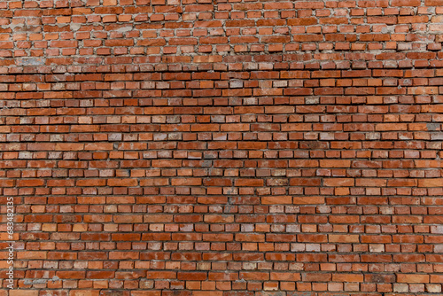 Red brick building scheduled for demolition, wrongly placed wall by the bricklayer