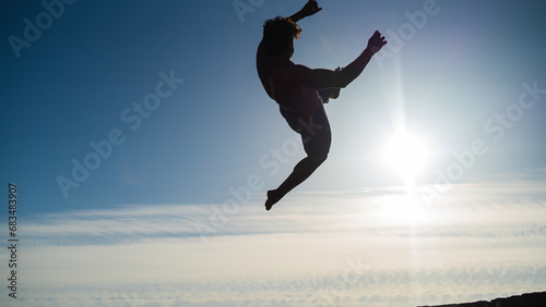 silhouette of a guy doing backflip in sunset