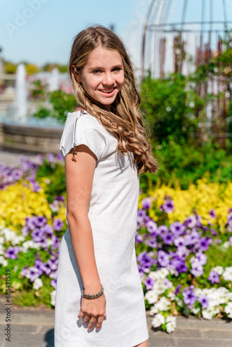 Cute teenage girl in a flower garden, portrait