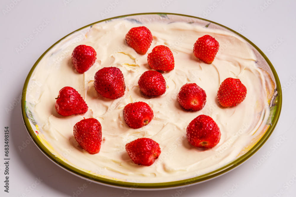 Fresh juicy strawberries in whipped cream in a plate on the table. Fresh juicy strawberries in whipped cream in a plate on the table.