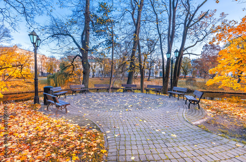 Golden autumn patterns, walkways and place for resting with garden benches in...