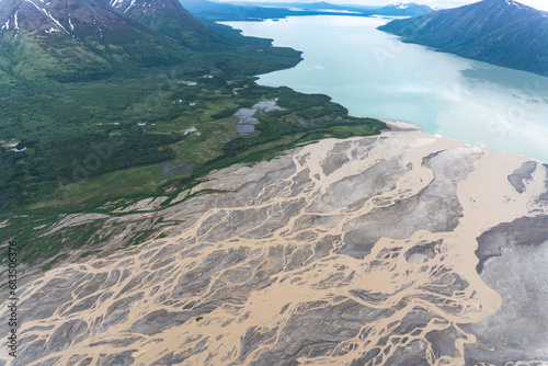 Ukak River flows into liuk Arm Naknek Lake in Katmai National Park, Alaska. Aerial view of river tan with suspended ash from Valley of Ten Thousand Smokes empties into glacial blue fresh water lake.  photo