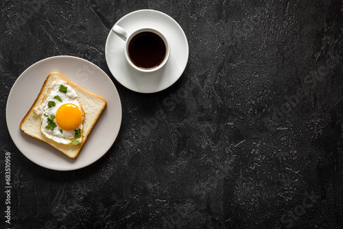 Breakfast with fried eggs on toast bread and cup of black coffee