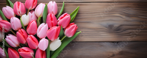Fresh pink and white tulips on a rustic wooden table background. Springtime celebrations. Valentine's and Mother's Day. Design for seasonal banners, invitations, or backdrops with free space for text