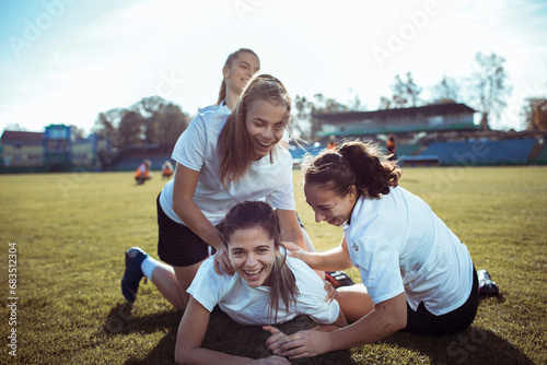 Team, success and winner by female soccer player celebration during game at football field photo