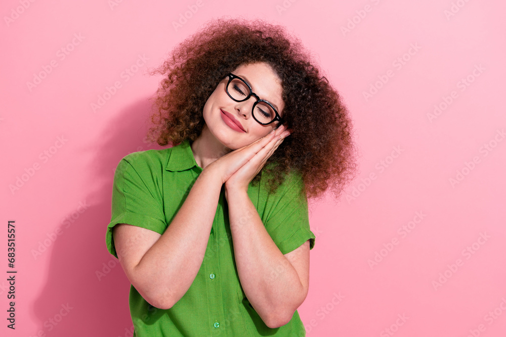 Photo of lovely adorable girl wear stylish green clothes arms touch face enjoy harmony sleep empty space isolated on pink color background Photo of lovely adorable girl wear stylish green clothes arms touch face enjoy harmony sleep empty space isolated on pink color background
