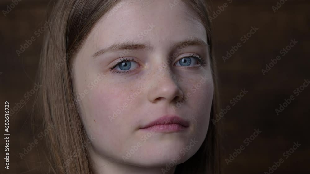 Portrait of beautiful young girl with blond hair and freckles looking up to the camera , close up Portrait of beautiful young girl with blond hair and freckles looking up to the camera , close up