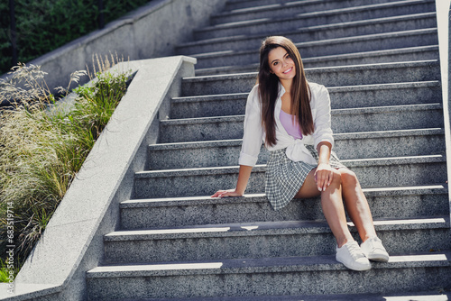 Full body portrait of pretty cheerful young lady have good mood sitting stairs spend pastime fresh air outside
