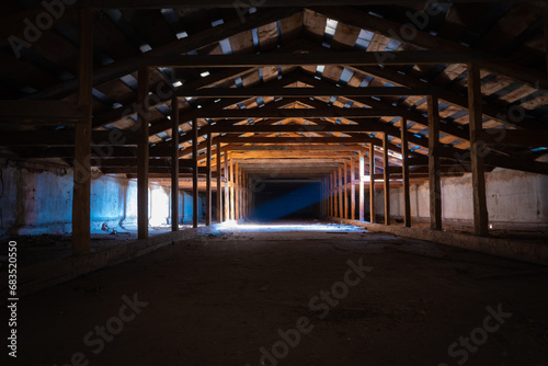 A ray of light penetrating through a window in a dark old abandoned attic