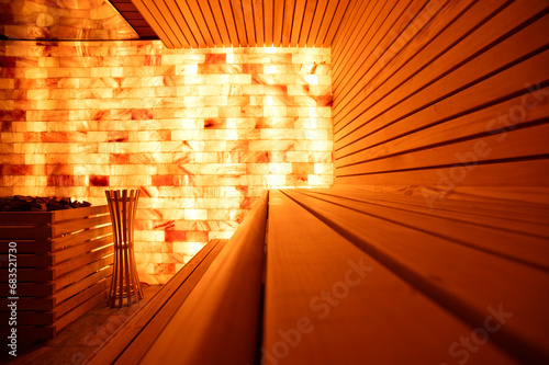 Salt room with wooden bench in spa. Salt brick wall in sauna.   photo