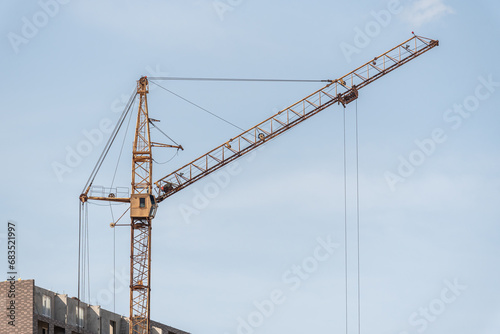 A construction site with a tower crane erecting a new house.