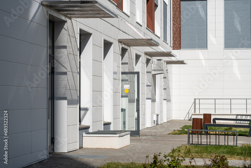 Modern courtyard of residential buildings with standing benches by the sidewalk.