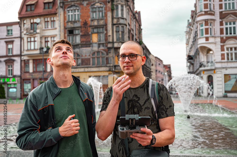 Two brothers operating drone in old city.