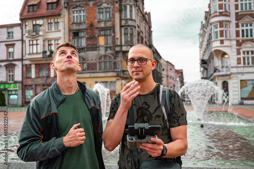 Obraz na płótnie Two brothers operating drone in old city. w salonie