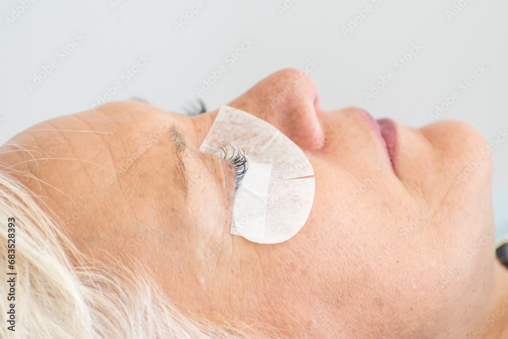 Fototapeta premium adult woman, blonde, in the beauty salon performing an eyelash perm