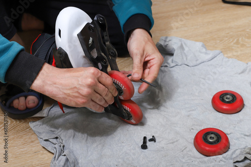 A Caucasian man repairs roller skates at home in order to save money
