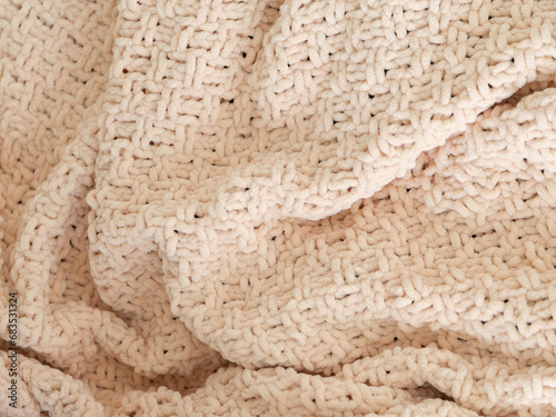 Beige knitted plaid close-up. Background. Creases on soft surfaces. © Sergei Dvornikov
