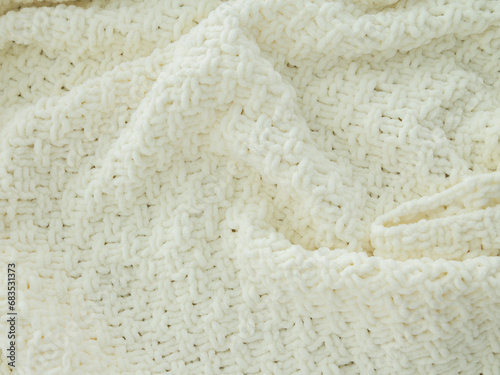 Background of white knitted plaid. Creases on soft surfaces.