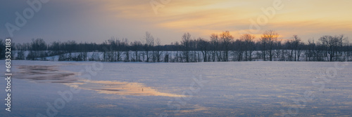 Winter sunset over a cold, icy field.