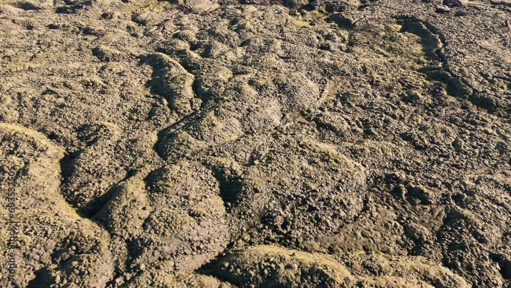 Aerial view of deserted vast area of brown extraordinary winding relief like alien-looking landscape along the road in Iceland on a sunny summer day. High quality 4k footage