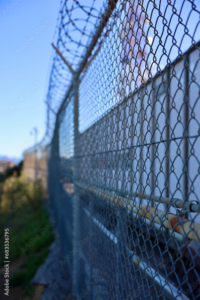 razor wire on top of a chainlink fence