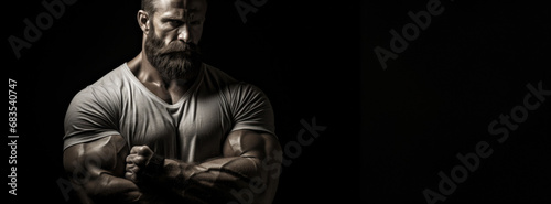 An athlete stands in a dimly lit space, his muscular definition showcased in a dramatic interplay of light and shadow, exuding strength and resilience.