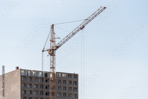 A construction site with a tower crane erecting a new house.