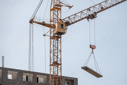 A construction site with a tower crane erecting a new house.