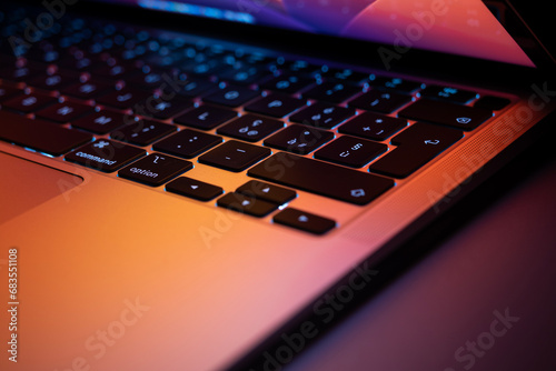 Keyboard of aluminum notebook, reflect screen highlight pink and orange color