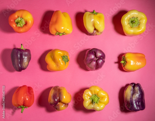 Grid of colorful bell peppers on pink photo