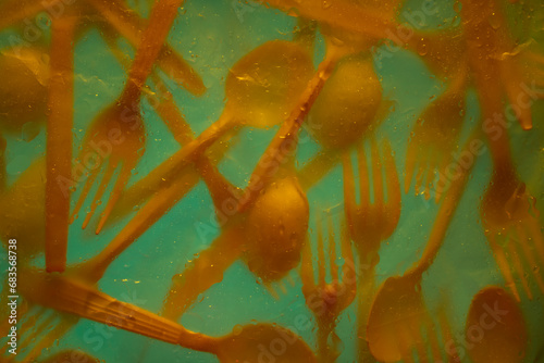 Yellow Plastic utensils backlit photo