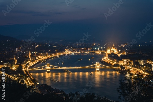 a long bridge across the water next to a mountain near the city: Hungary, Budapest