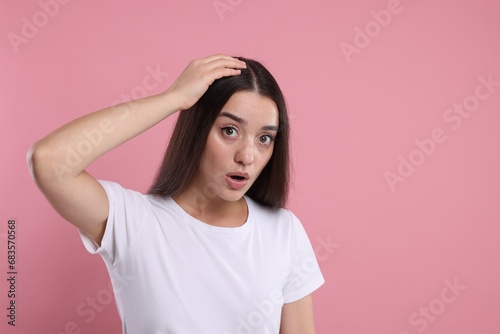 Emotional woman with healthy dark hair on pink background, space for text. Dandruff problem