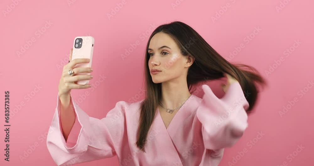 The girl stares at the phone and fixes her hair. Female uses phone like ...