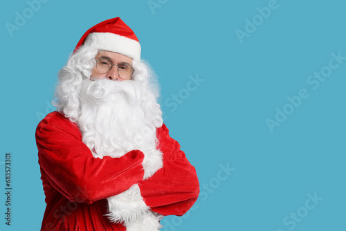 Merry Christmas. Santa Claus posing on light blue background, space for text
