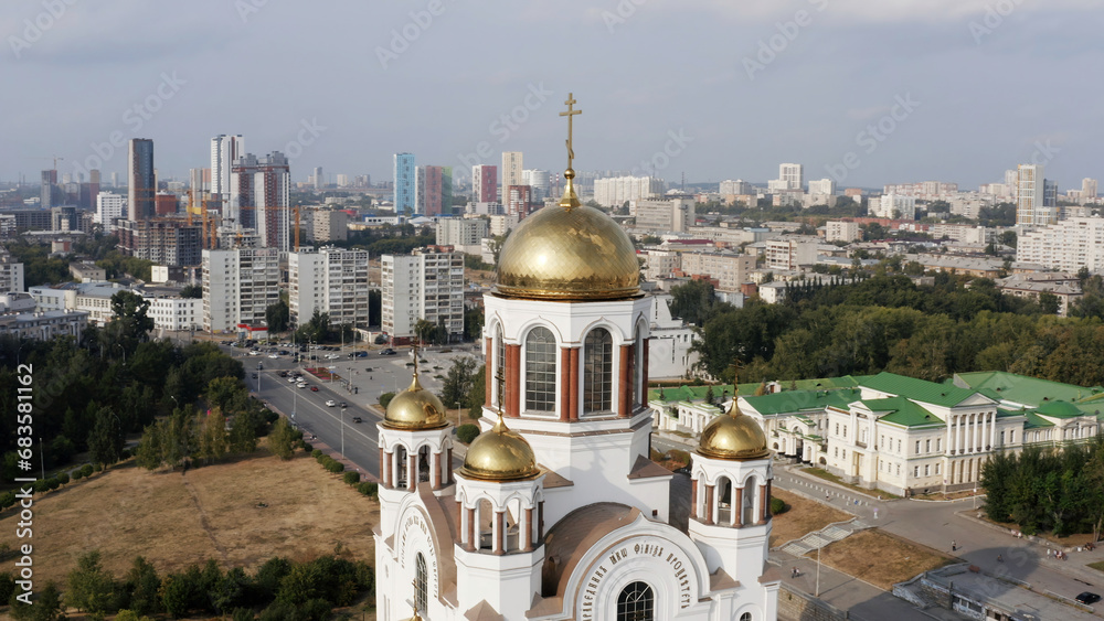 Obraz premium Orthodox white church building with golden domes outdoors. tock footage. Christianity religion, cathedral or temple with the big summer city on the background.