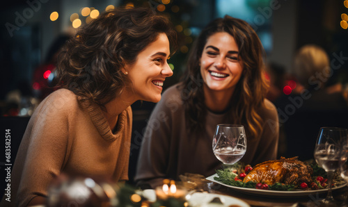 Two girls gossip  chat and laugh heartily in a restaurant against the background of a cozy festive interior. Sincere female friendship