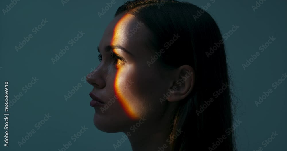Young female in profile standing in studio isolated in bright light looking up playing with light dansinc with hands. Multicolour future of advertisement concept futuristic time. Young female in profile standing in studio isolated in bright light looking up playing with light dansinc with hands. Multicolour future of advertisement concept futuristic time.