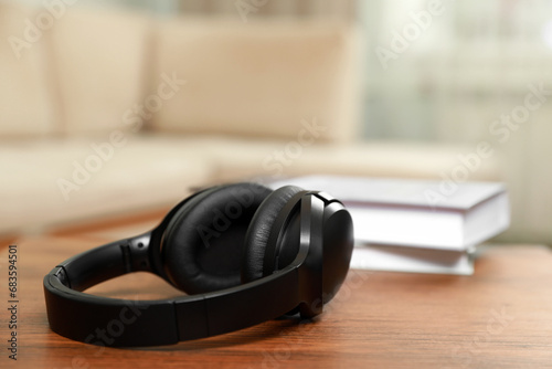 Modern wireless headphones on wooden table indoors