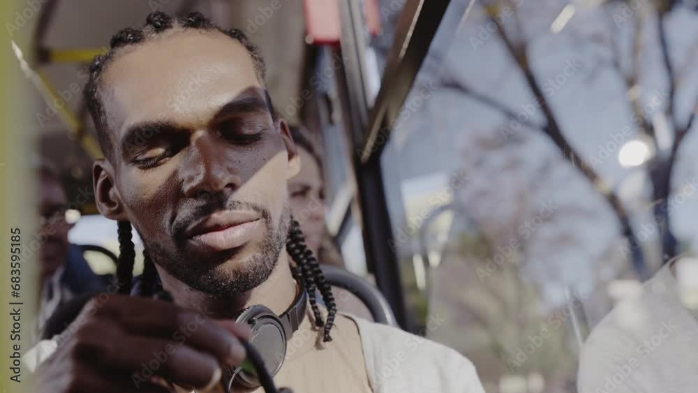 Jovem negro usando smartphone durante uma viagem de onibus. Cinematico 4k.