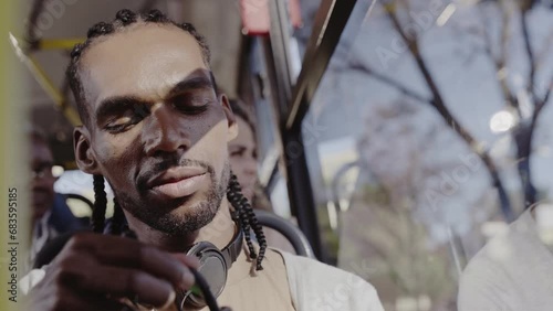 Jovem negro usando smartphone durante uma viagem de onibus. Cinematico 4k. photo