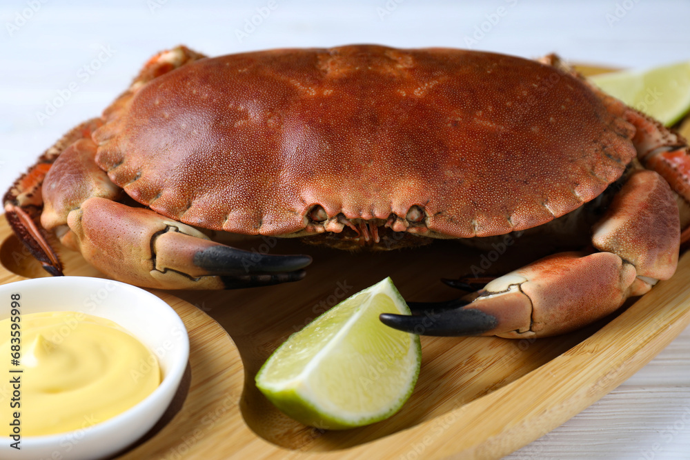 Delicious boiled crab served with lime and sauce on white table, closeup Delicious boiled crab served with lime and sauce on white table, closeup