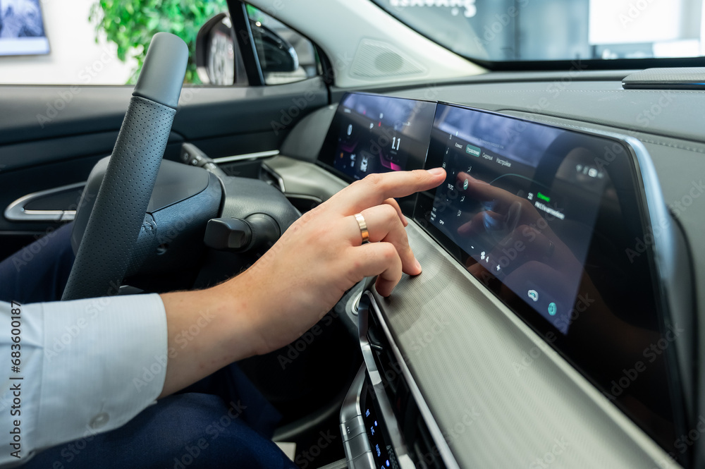 Close-up of a man's hands on the dashboard of a modern car. 