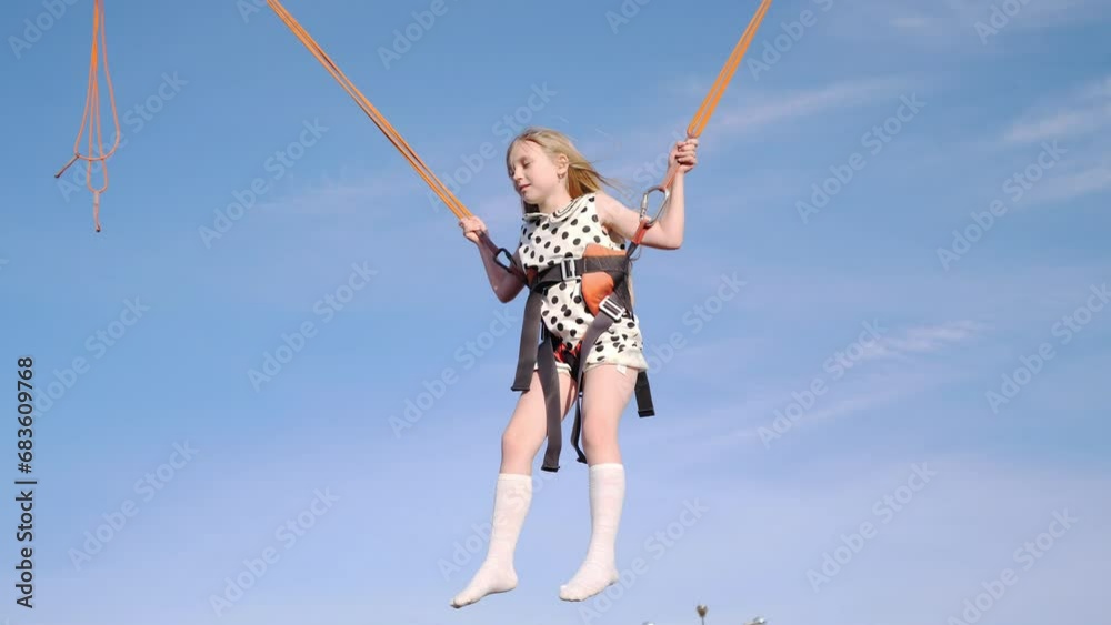 Little cheerful girl having fun in the park in the summer jumping on a trampoline slow motion Little cheerful girl having fun in the park in the summer jumping on a trampoline slow motion